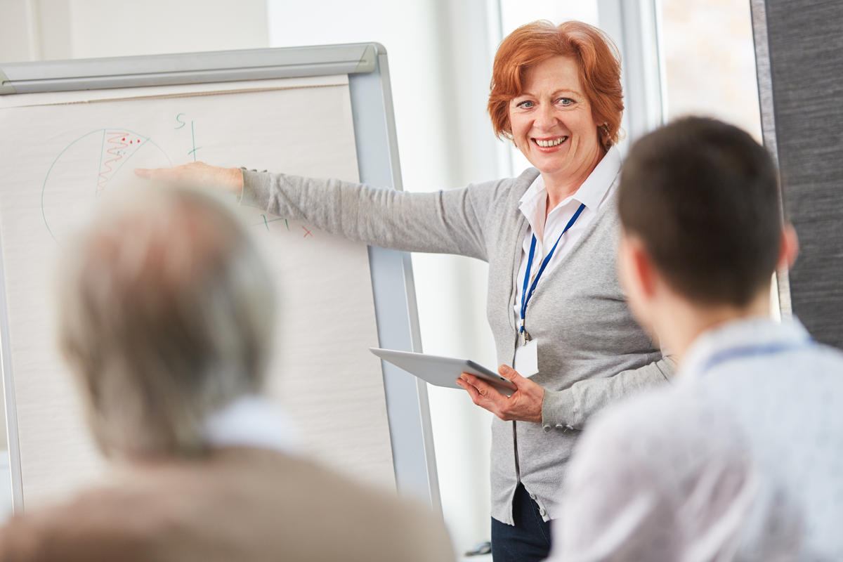 Woman leading a consultation, standing at a flipchart