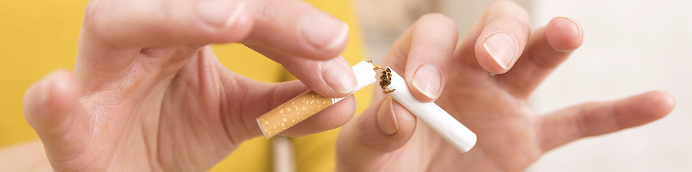 close-up of hands snapping a cigarette in half