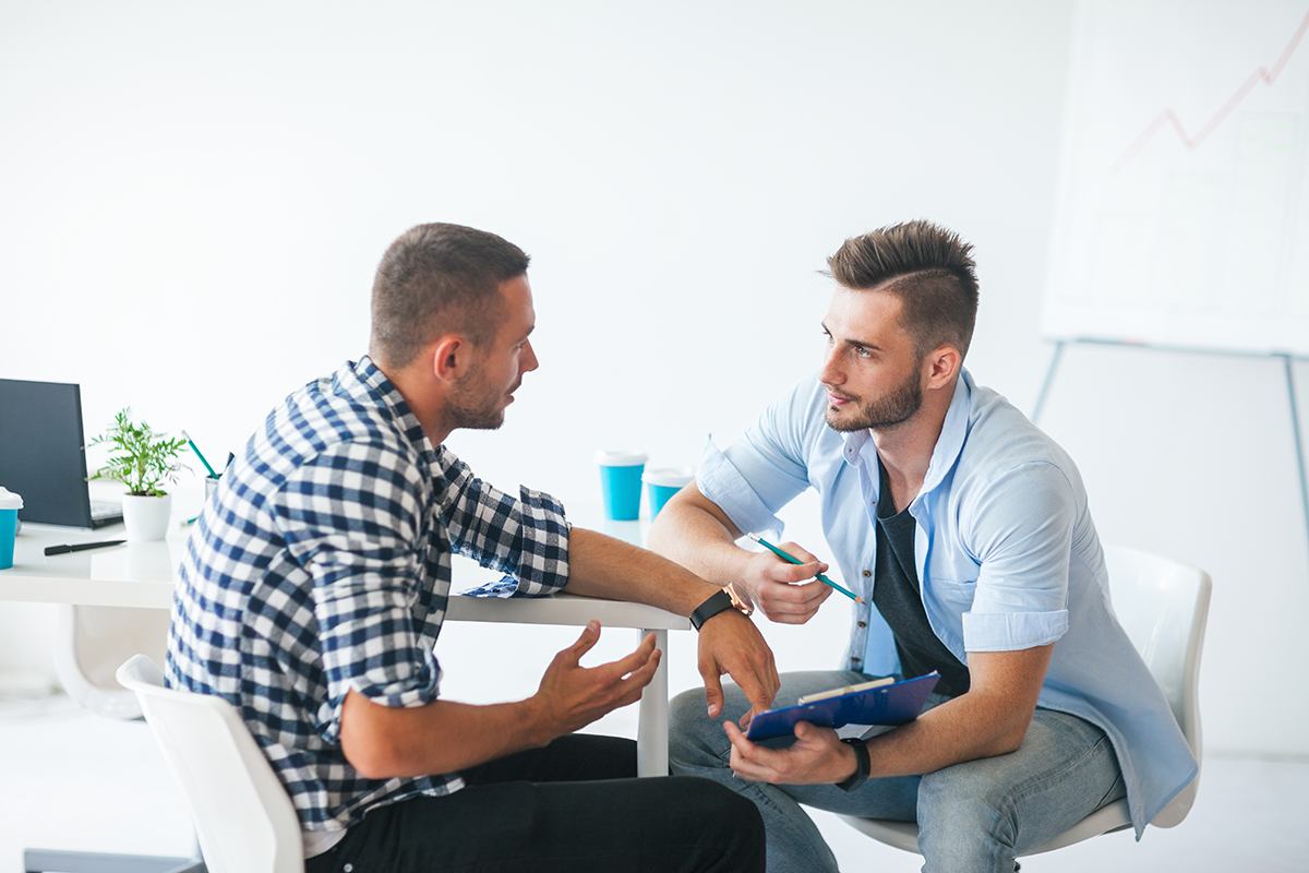 Two people talking sat at a table