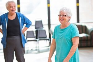 image shows elderly couple enjoying a fitness class together