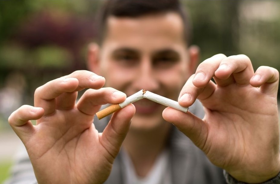 Man snapping a cigarette in half