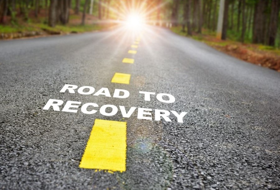 a road with the text: 'road to recovery' painted on it