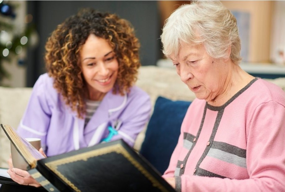 female befriender reading with an elderly lady