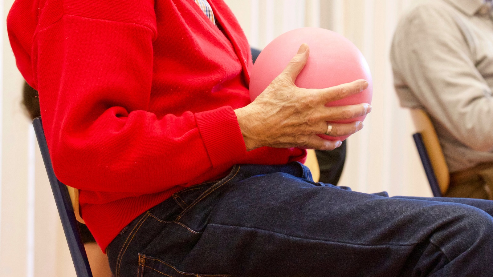 Older person holding an exercise ball