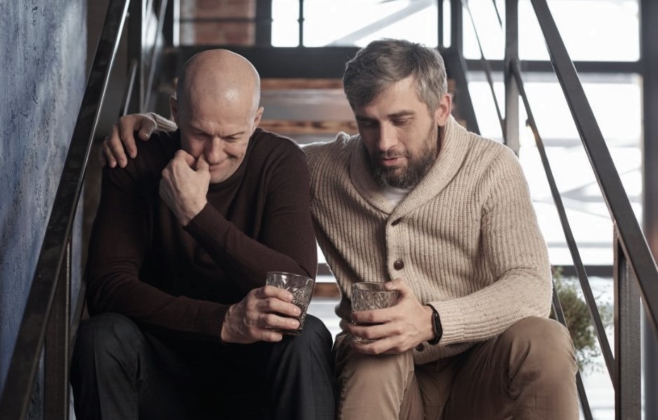 two men sitting talking on stairs