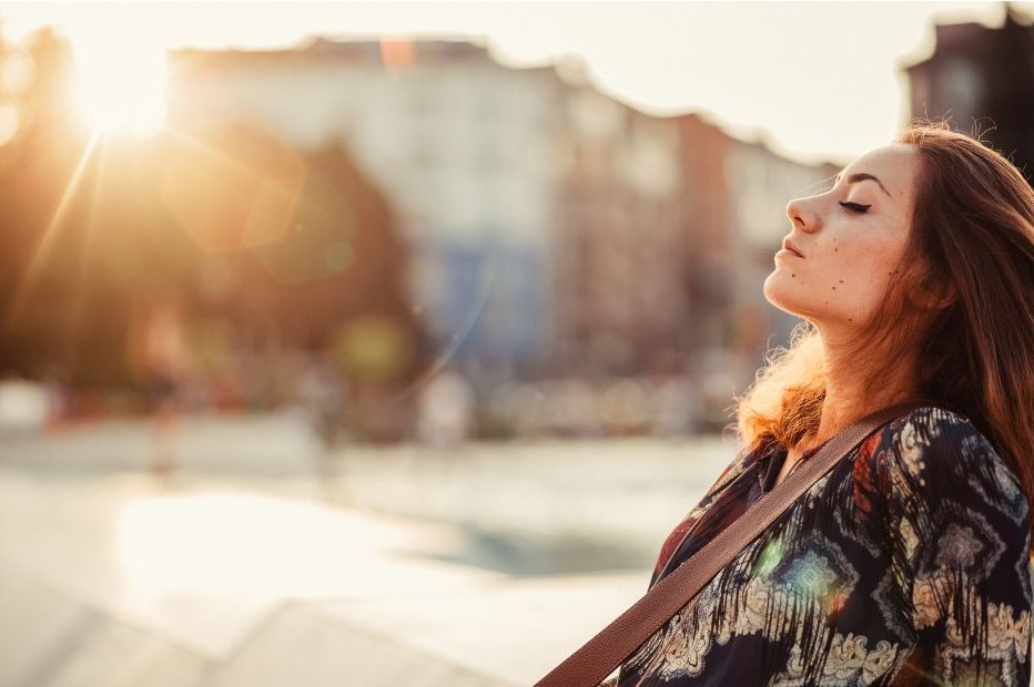 Young woman standing outside with a calm expression on her face