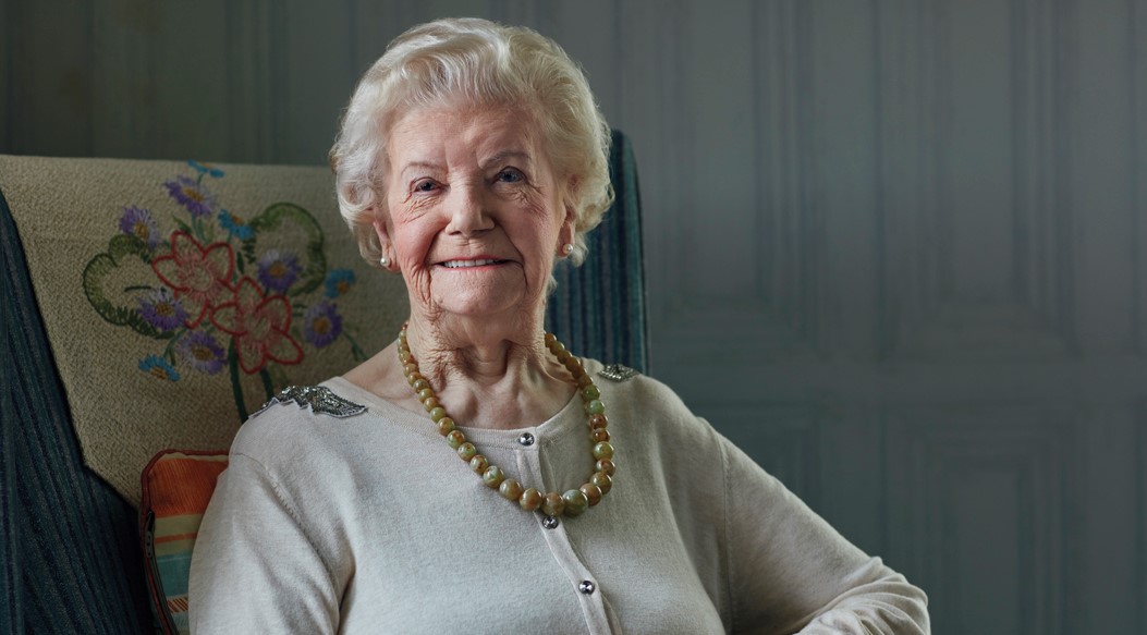 Elderly lady smiling while sitting in her chair