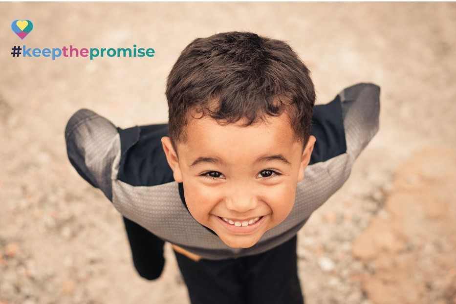 Young boy smiling while looking up at the camera