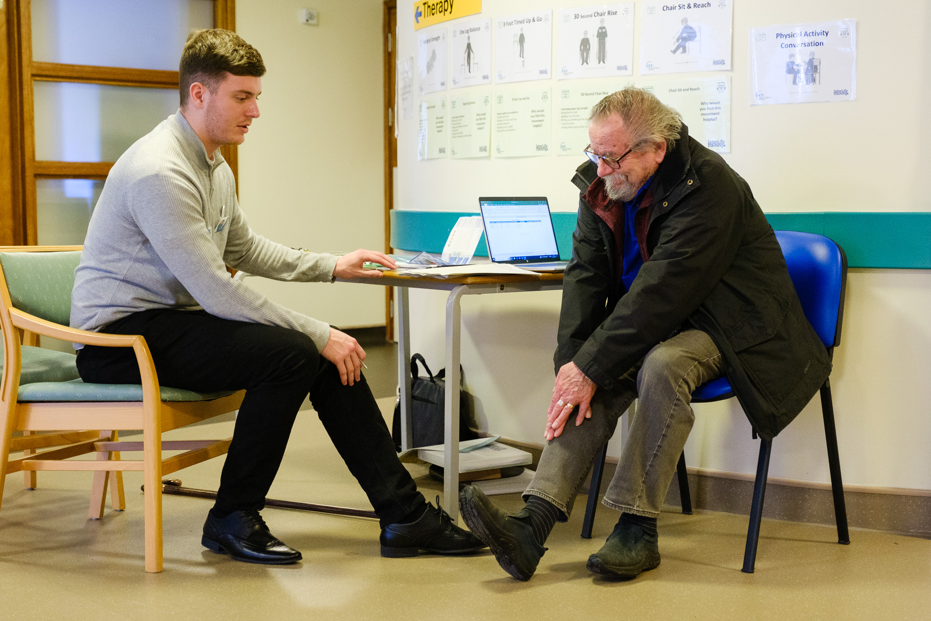 A volunteer providing advice to an elderly gentleman at the event