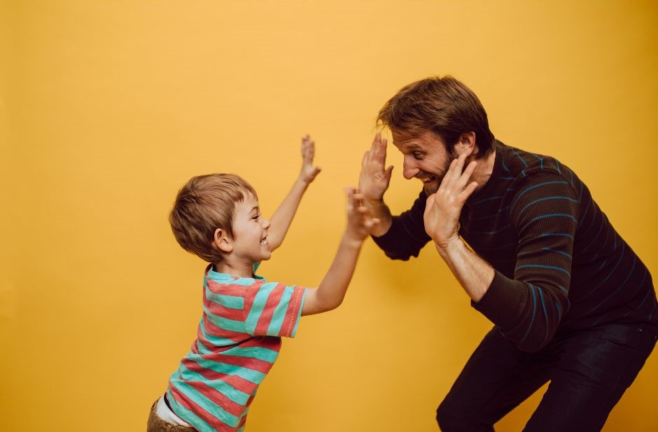 A father doing high fives with his son