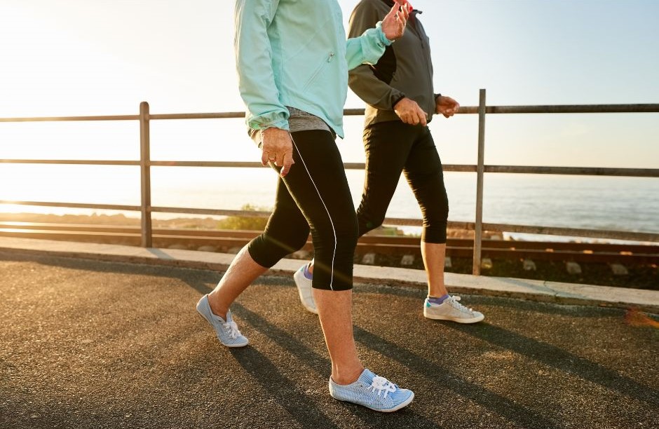 Two women walking along a beach path